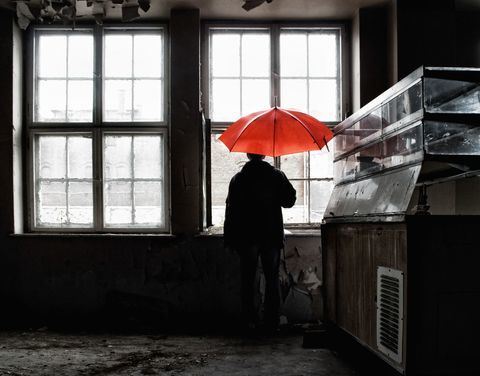 Muž, který držel červený deštník otevřený uvnitř budovy