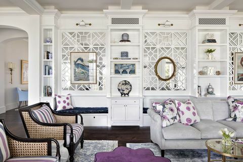 obývací pokoj, šedá pohovka, fialové a bílé dekorační polštáře, bílé úložné skříňky, fialový otoman