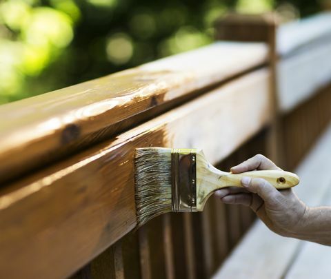 Muž Carpenter použití laku na dřevěný nábytek.