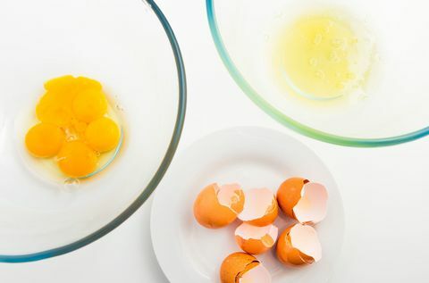 Vaječný žloutek a vejce bílé v oddělené skleněné míse. Vejce a vejce na bílé desce.