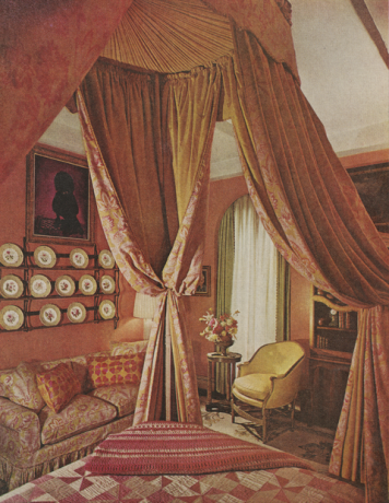 ložnice s portrétem pudla, dekorativní talíře na zdi, vzorované růžové povlečení
