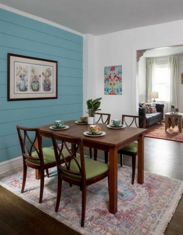 jídelna, jídelní dřevěný jídelní stůl s dřevěnými a zelenými polstrovanými jídelními židlemi, koberec, modrá stěna lodi