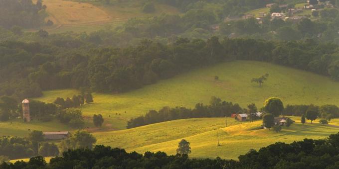 mlhavý východ slunce nad zvlněnými zelenými kopci Middlesboro, Kentucky