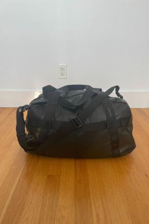 černá taška na dřevěné podlaze