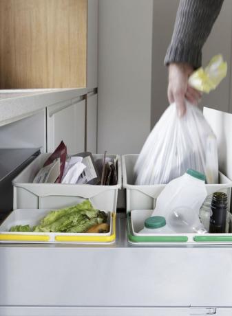 Osoba, která odstraňuje pytel na odpad z odpadní a recyklační zásuvky