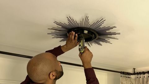 muž vrtání zrcadla do stropu