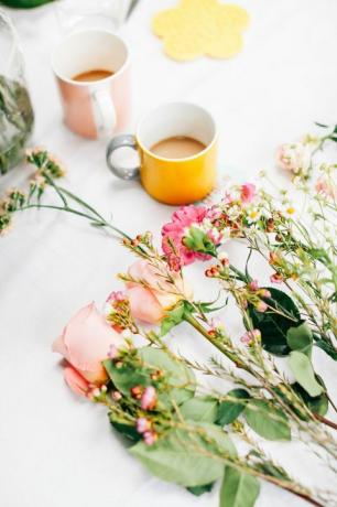 Tabulka s řezané květiny a šálky na kávu v aranžování květin dílna