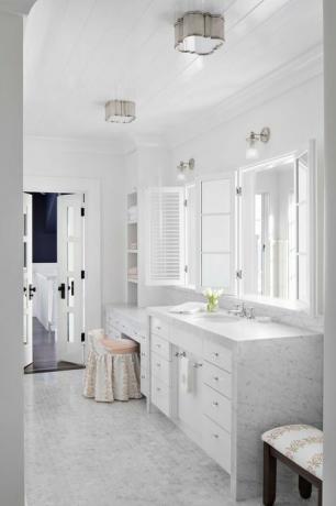 mramorová koupelna, mramorové desky, malé mramorové šestihranné dlaždice, bílé skříňky, bílé zrcadlo, toaletní sedátko a stolička