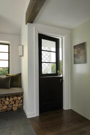 vchod, dveře černého poníka, hromádka dřeva, sedadlo u okna