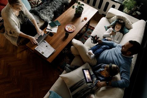 Vysoký úhel pohledu na rodinu pomocí různých technologií v obývacím pokoji doma