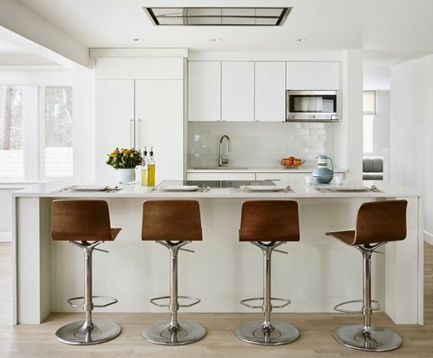 bílé kuchyňské skříňky, hnědé kožené barové židle