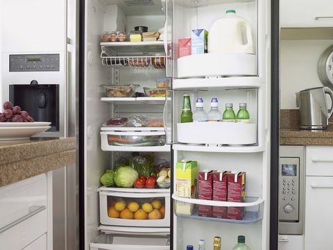 Jídlo a pití v plné domácí lednici s otevřenými dveřmi