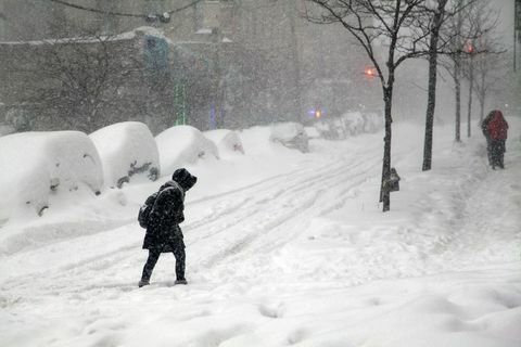 Žena křižovatky ulice během sněhové vánice Jonas v Bronxu
