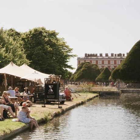 návštěvníci relaxují v kuka baru u dlouhé vody na zahradním festivalu rhs hampton court palace 2022