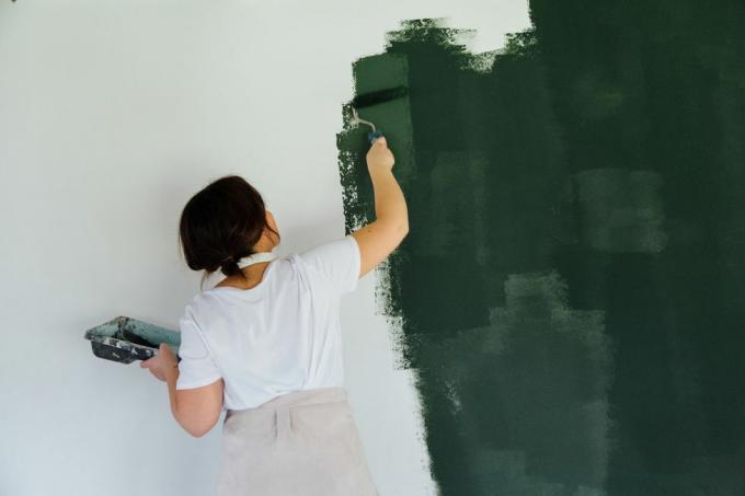 žena v hlavě telefony malování bílé zdi v zelené barvě