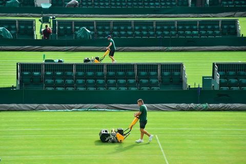 Pozemní personál seká trávu na hřišti v All England Lawn Tennis Club ve Wimbledonu