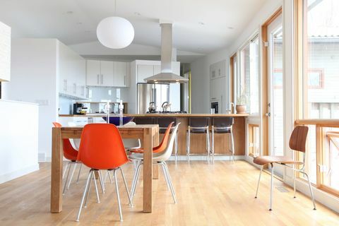 Švédská moderní kuchyně: Čistá bílá moderní kuchyně s barevnými moderními kuchyňskými židlemi z poloviny století